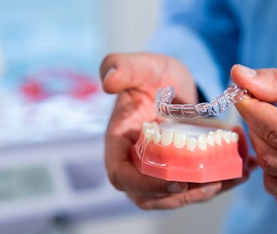 Dentist holding an aligner with a mouth mold