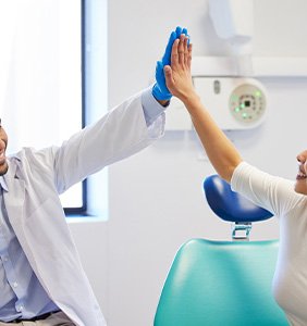 Smiling dentist and patient giving each other a high-five