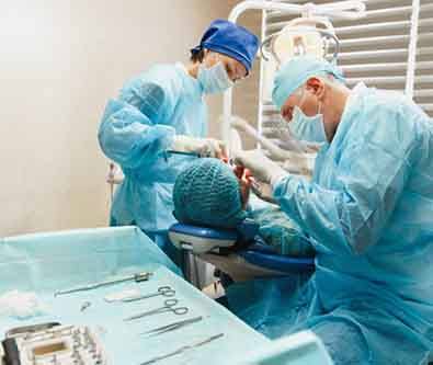 an oral surgeon performing dental implant placement surgery