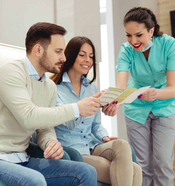 Two dental patients looking at dental insurance pamphlet