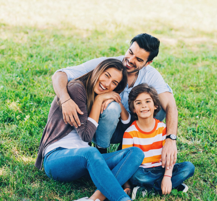 Family of three smiling outdoors after saving with dental membership plan in Waverly