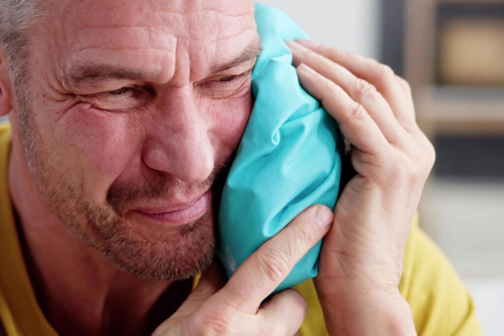 A man holding an icepack to his jaw