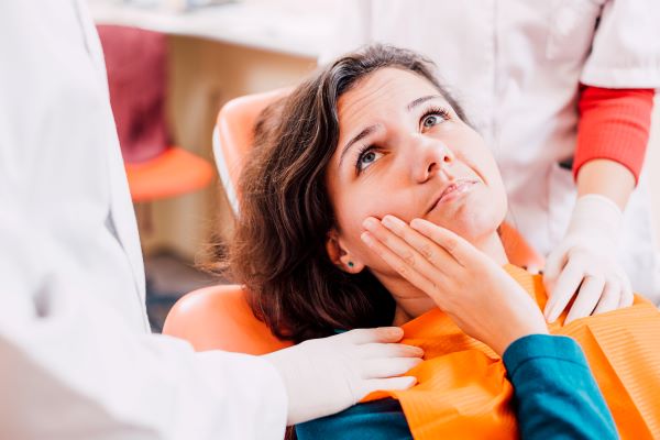 A woman with a toothache at the dentist