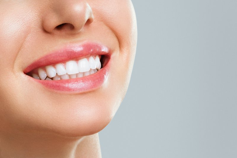 A closeup of a beaming young woman with a white smile